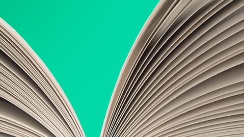 Close up of an open book against a turquoise background