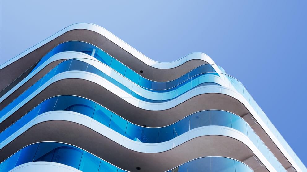 Building facade with glass balconies on blue background